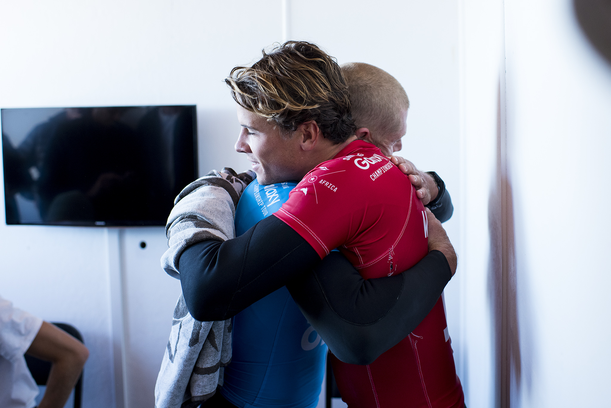 Julian Wilson hugs Mick Fanning (Blue) from the safety of shore after Fanning was attacked by a shark during the FInal of the JBay Open on Sunday July 19, 2015.