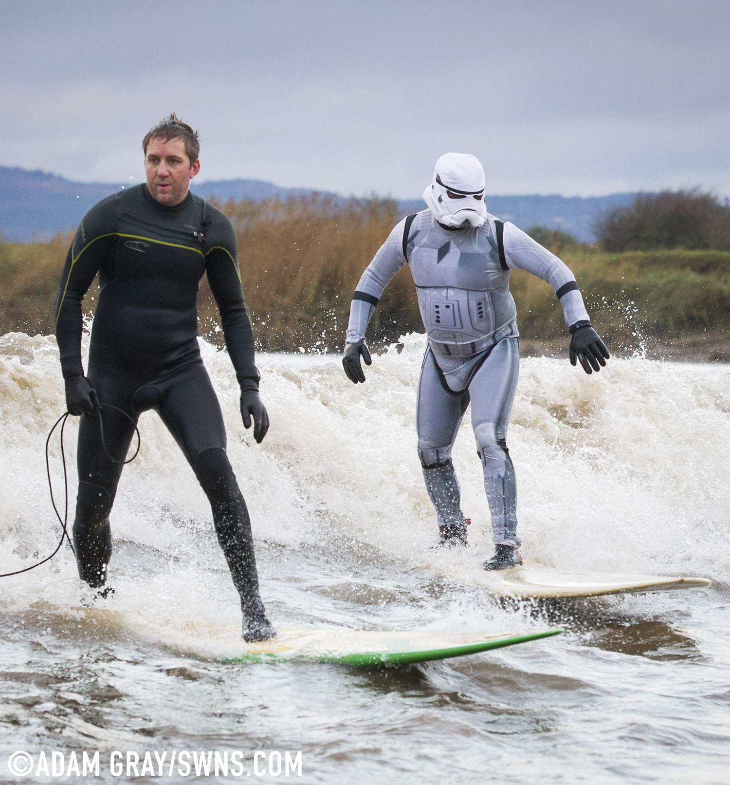 A surfer dressed as a Star Wars Stormtrooper rides the Severn Bore in Gloucestershire. 27 November 2015. See SWNS story SWTROOPER: There was an unworldly sight in the Forest of Dean this morning (Friday 27th November) when a trio of Star Wars Stormtroopers surfed the spectacular Severn Bore. Key scenes from the upcoming Star Wars episode VII were filmed in nearby Puzzlewood and can be seen several times in the trailer. Swapping the Death Star for surfboards, the elite soldiers of the Galactic Empire took to the waves to mark the release of the highly anticipated new Star Wars film and a new TV & Movie Trail. The Forest of Dean’s atmospheric and picturesque location provided a natural stage for the film, which director J.J Abrams referenced in a thank you letter to all of the movie's cast and crew.