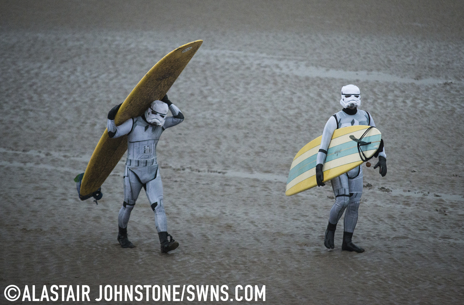 Surfers dressed as a Star Wars Stormtroopers wait for the Severn Bore on the River Severn in Gloucestershire, England. November 27 2015.  See SWNS story SWTROOPER: There was an unworldly sight in the Forest of Dean this morning (Friday 27th November) when a trio of Star Wars Stormtroopers surfed the spectacular Severn Bore. Key scenes from the upcoming Star Wars episode VII were filmed in nearby Puzzlewood and can be seen several times in the trailer.  Swapping the Death Star for surfboards, the elite soldiers of the Galactic Empire took to the waves to mark the release of the highly anticipated new Star Wars film and a new TV & Movie Trail. The Forest of Dean’s atmospheric and picturesque location provided a natural stage for the film, which director J.J Abrams referenced in a thank you letter to all of the movie's cast and crew.