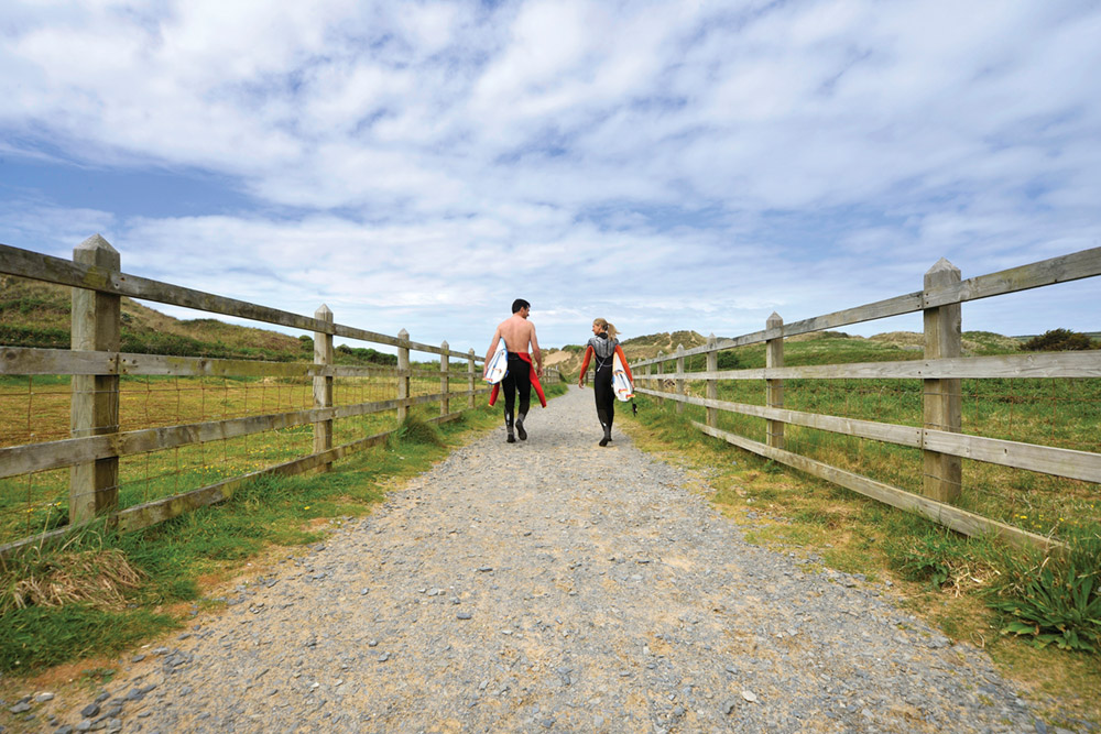 Surfers-walking-down-to-Croyde-Bay-from-Surfer's-Paradise-Campsite