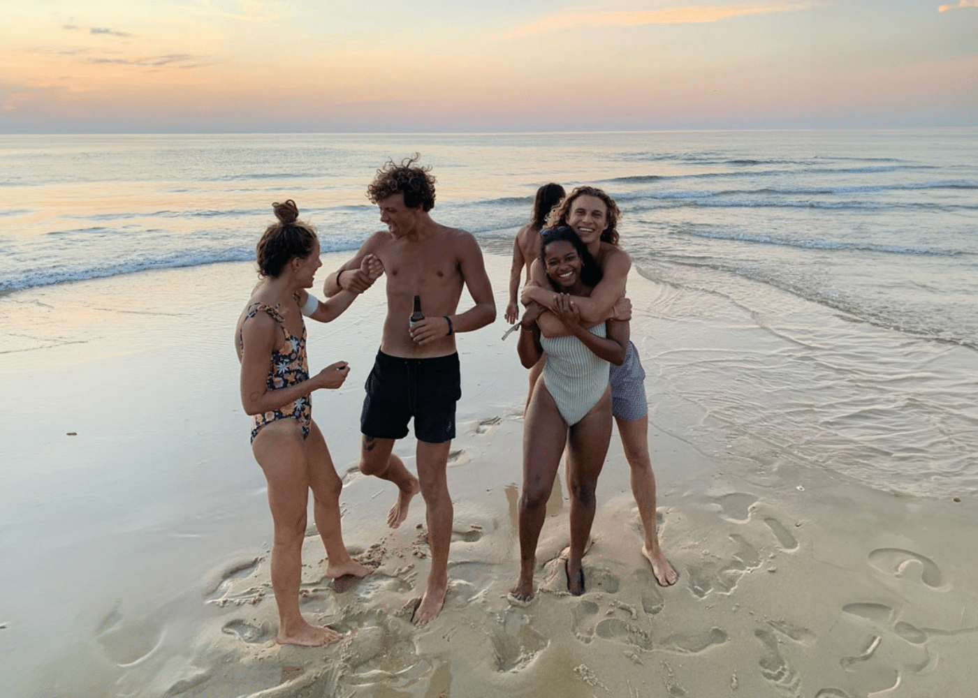 Friends on the beach at sunset whilst at Yume Surfcamps