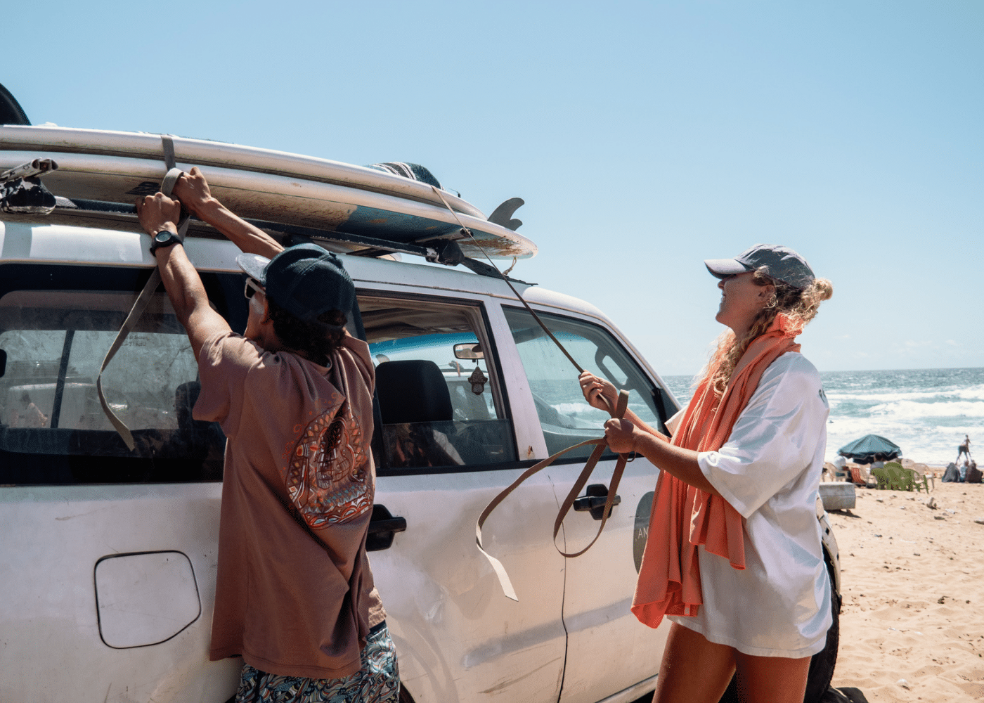 Tying surfboards to the top of the van at Amayour Surf & Yoga