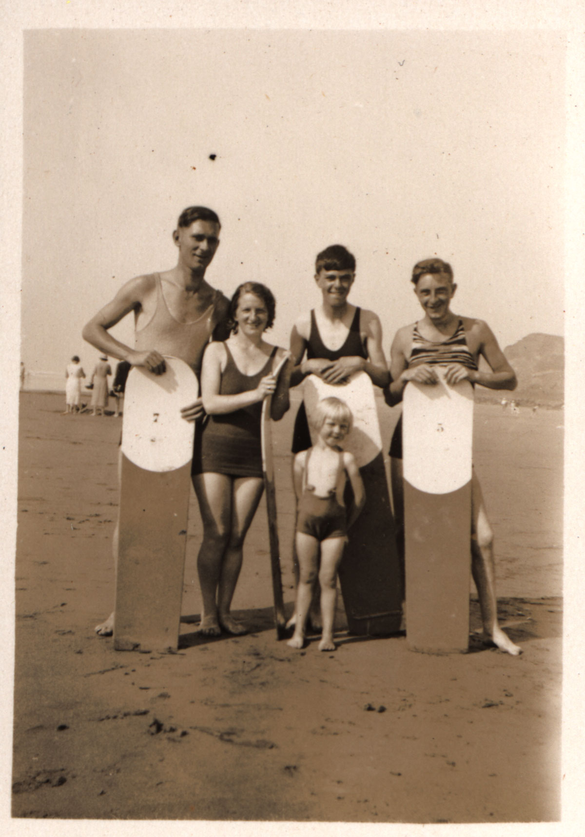 Surfers holding wooden bellyboards on the beach at Bude in 1932
