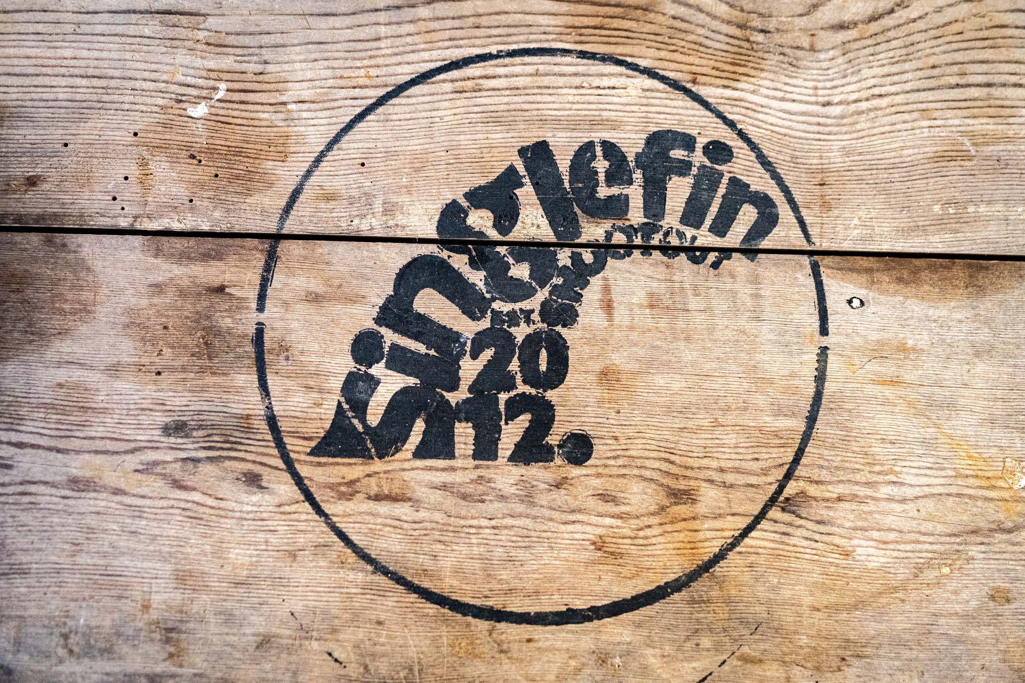 Singlefin logo stamped on weathered wood